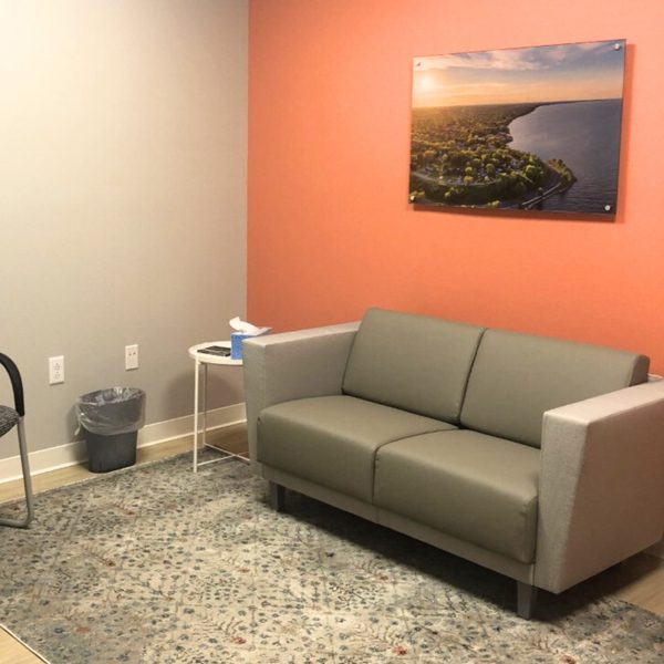 Client room with a couch, chair and rug